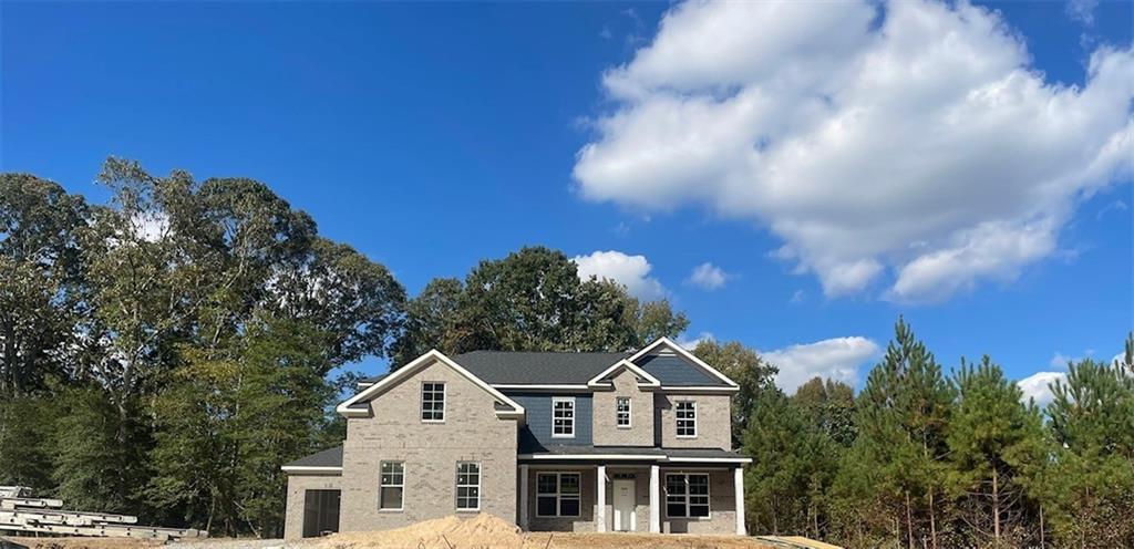 a front view of a house with a yard and mountain view in back