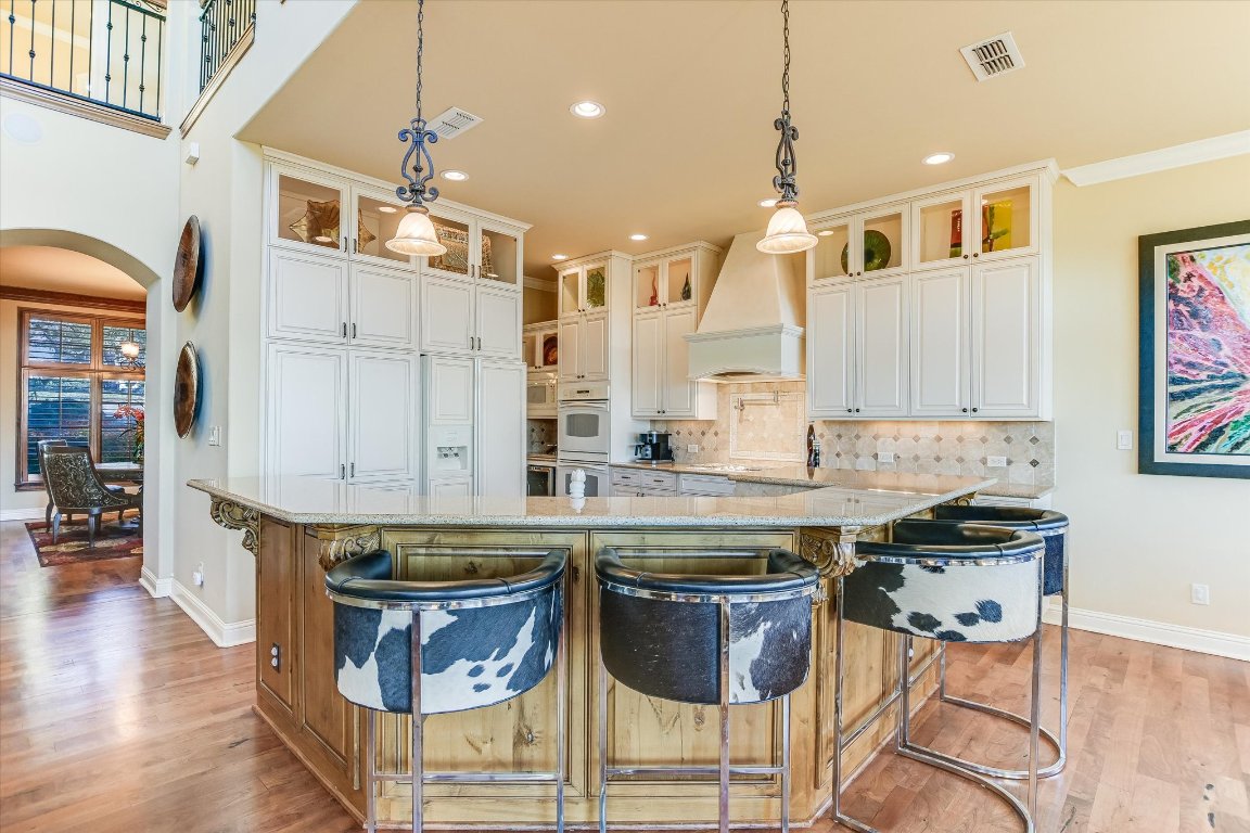 633 Wesley Ridge Drive Spicewood, TX 78669 - Photo 16 of 40 Sure to please the family chef, the kitchen is equipped with a wine 'fridge, large pantry, and top-tier appliances, blending style with functionality for both everyday meals and entertaining.