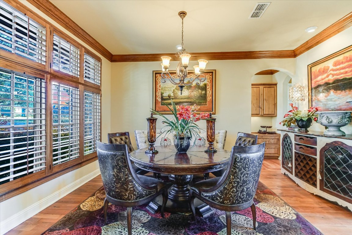 633 Wesley Ridge Drive Spicewood, TX 78669 - Photo 18 of 40 Formal dining room offers an elegant setting with warm wood accents, abundant natural light, and classic plantation shutters. A built-in office nook sits just beyond.