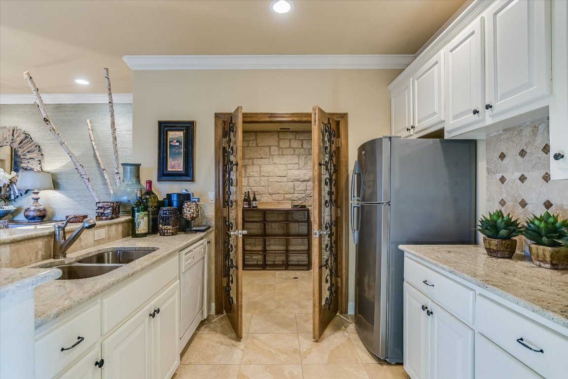 633 Wesley Ridge Drive Spicewood, TX 78669 - Photo 32 of 40 In addition to the wine cellar, the kitchenette includes a dishwasher and fridge making it ideal for entertaining or to be used as a convenient "in-law "suite.
