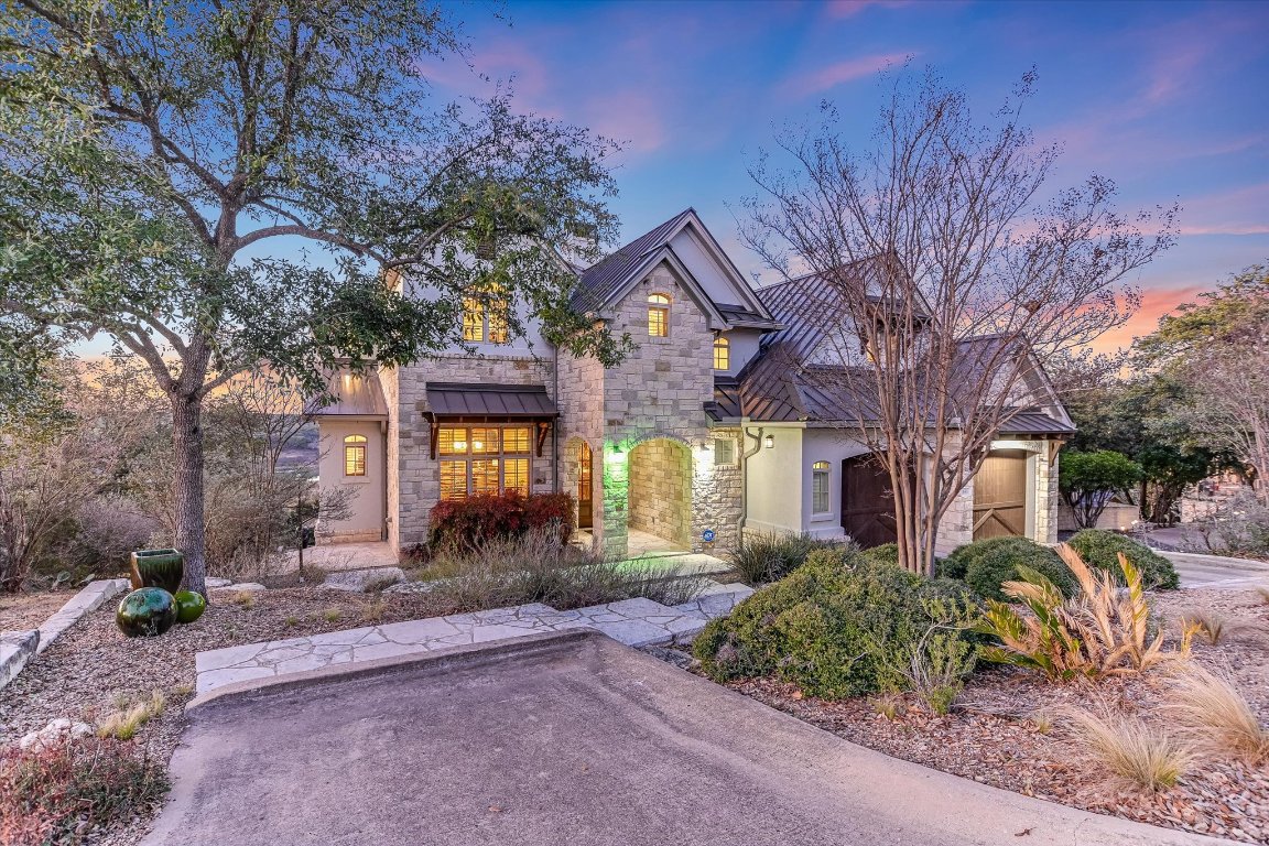 633 Wesley Ridge Drive Spicewood, TX 78669 - Photo 40 of 40 Positioned on a waterfront lot directly above Lake Travis, 633 Wesley Ridge is a striking blend of stone and stucco, enhanced by warm lighting showcasing a timeless curb appeal. The home is move-in ready and waiting for a new family to embrace the lake lifestyle and make it their own.