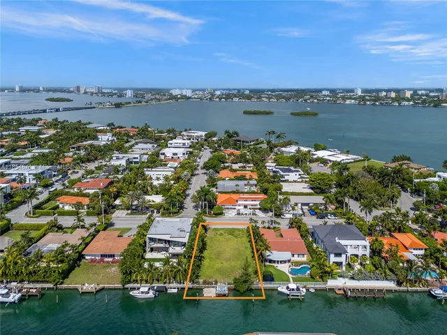 an aerial view of residential houses with outdoor space and lake view