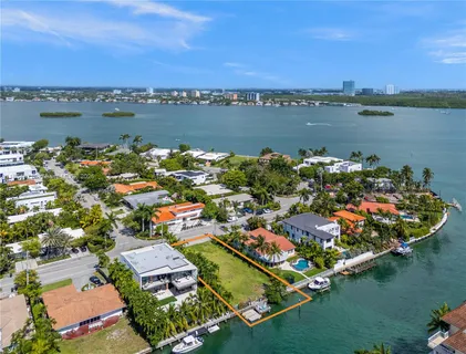 an aerial view of residential houses with outdoor space and lake view