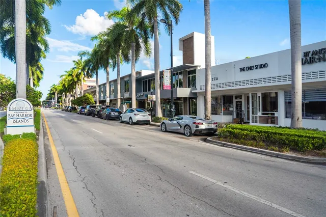 a view of a street with cars parked in front of it