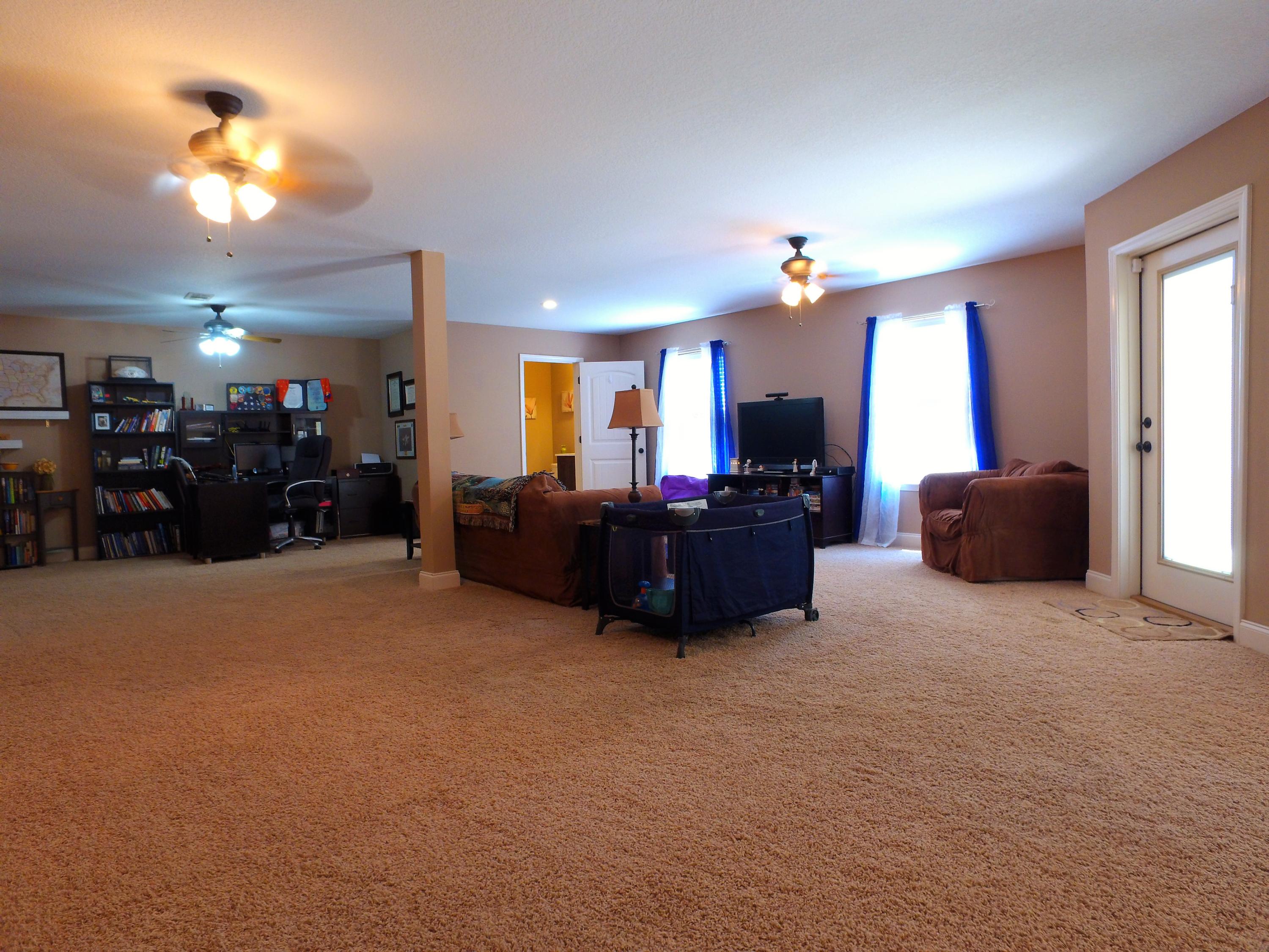 4568 Hermosa Road Crestview, FL 32539 - Photo 37 of 51 a living room with furniture a chandelier and a flat screen tv
