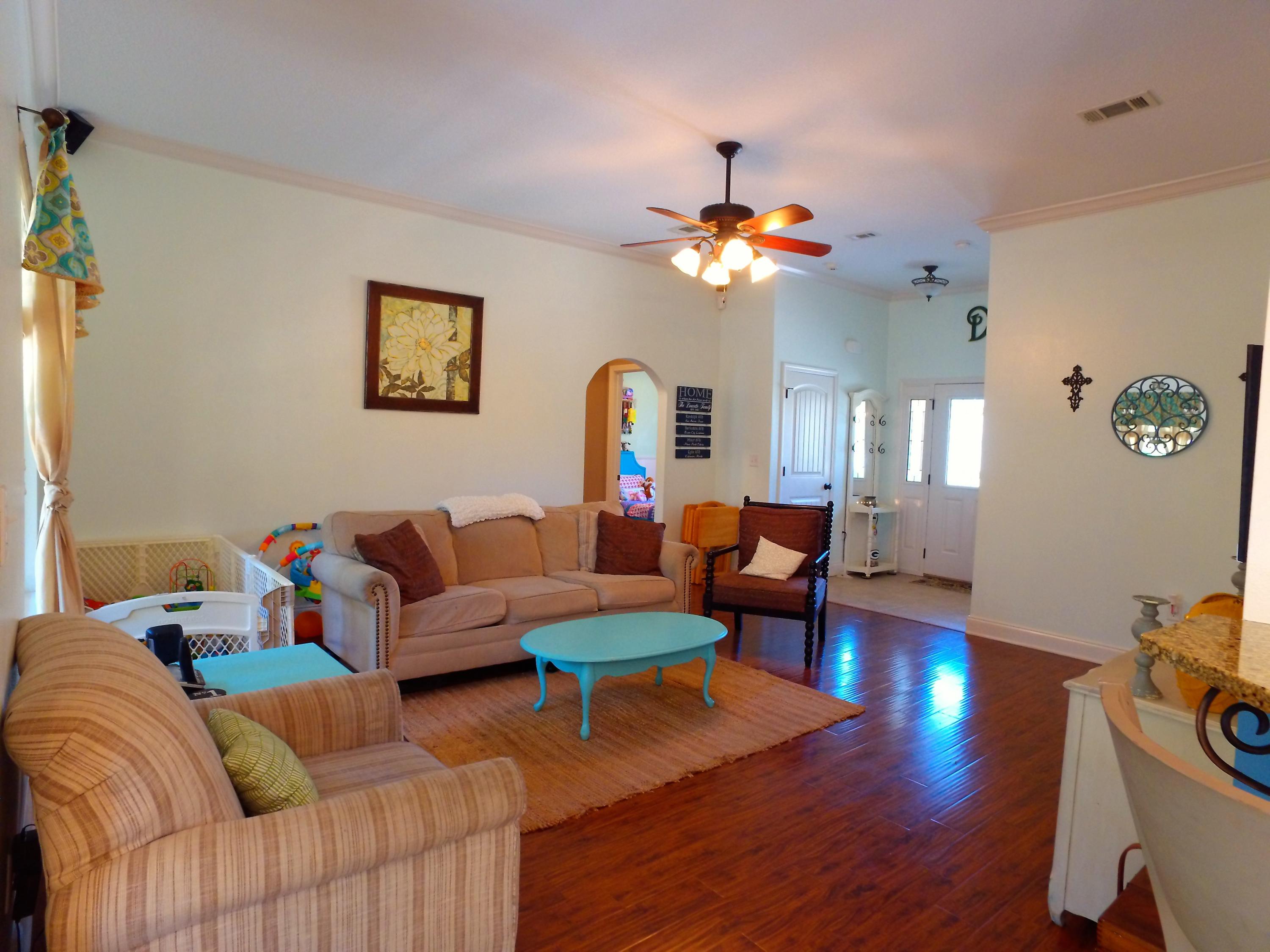 4568 Hermosa Road Crestview, FL 32539 - Photo 6 of 51 a living room with furniture a chandelier and a wooden floor