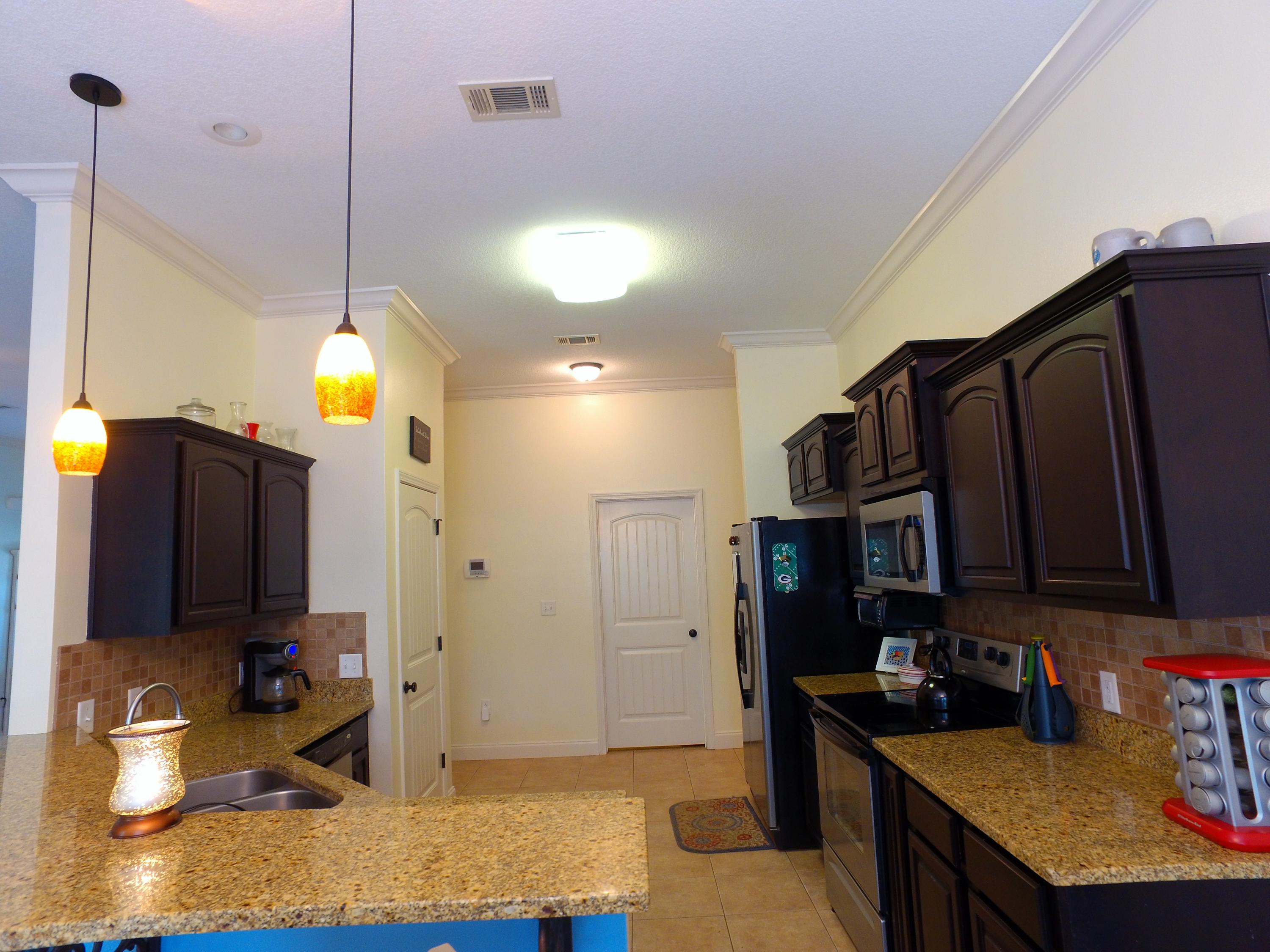 4568 Hermosa Road Crestview, FL 32539 - Photo 10 of 51 a kitchen with stainless steel appliances granite countertop a sink a stove and a refrigerator