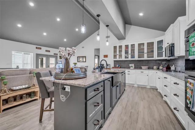 a kitchen with stainless steel appliances granite countertop a stove and a wooden floors