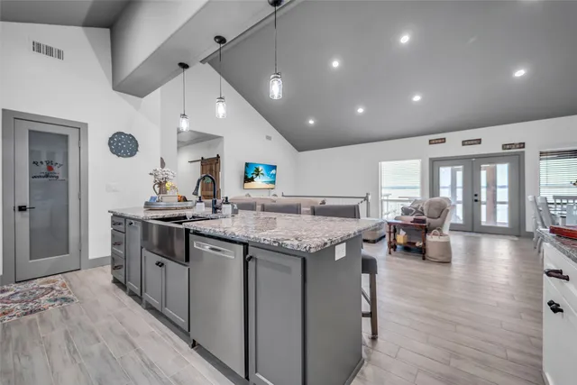 a kitchen with granite countertop a sink and a stove top oven