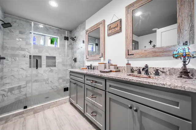 a bathroom with a granite countertop sink mirror and shower