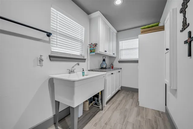 a kitchen with a sink cabinets and wooden floor