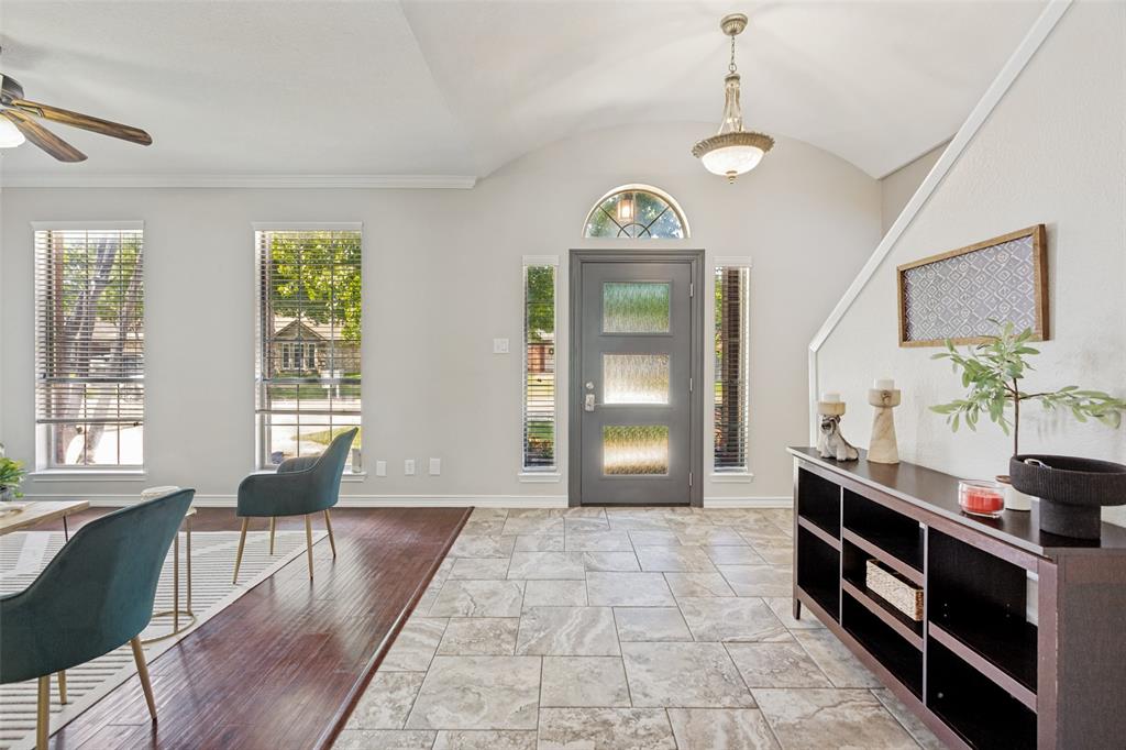 1228 Concho Drive Benbrook, TX 76126 - Photo 5 of 39 Inviting entryway with a vaulted ceiling, presenting a paneled door with frosted glass inserts, an arched transom window, and a decorative chandelier