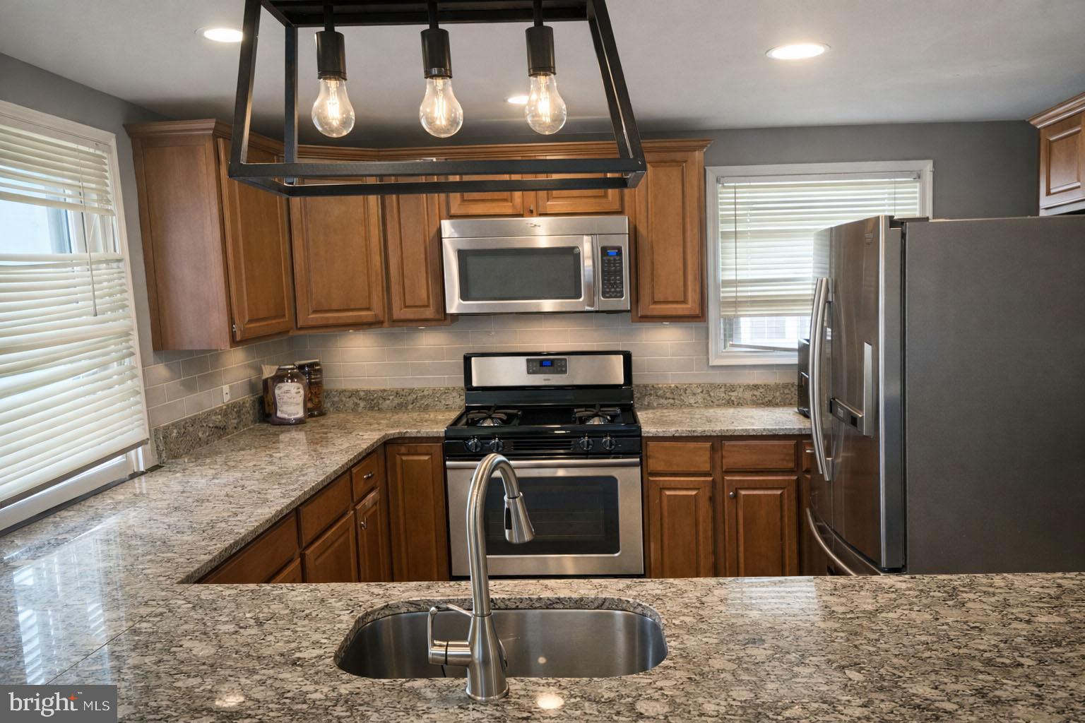 1018 West Browning Road Bellmawr, NJ 08031 - Photo 2 of 15 a kitchen with stainless steel appliances granite countertop a stove a sink and a microwave