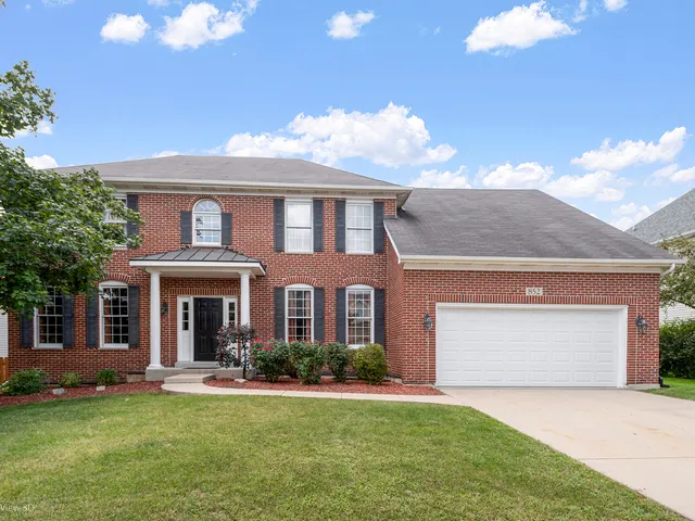 a front view of a house with a garden and yard