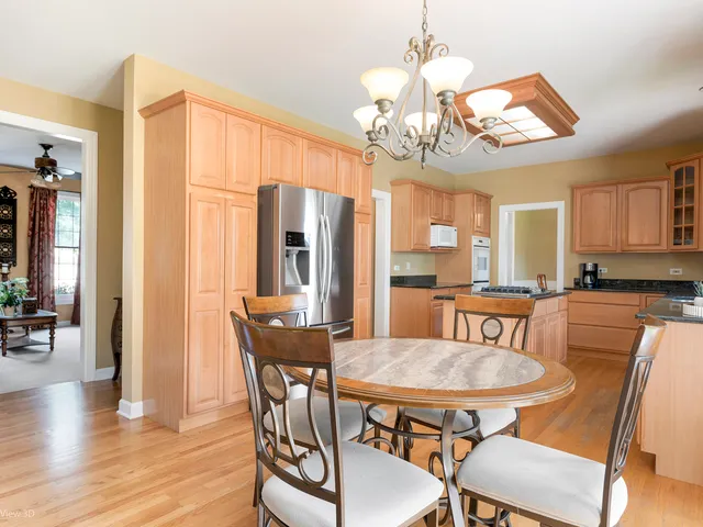 a view of a dining room with furniture a chandelier and wooden floor
