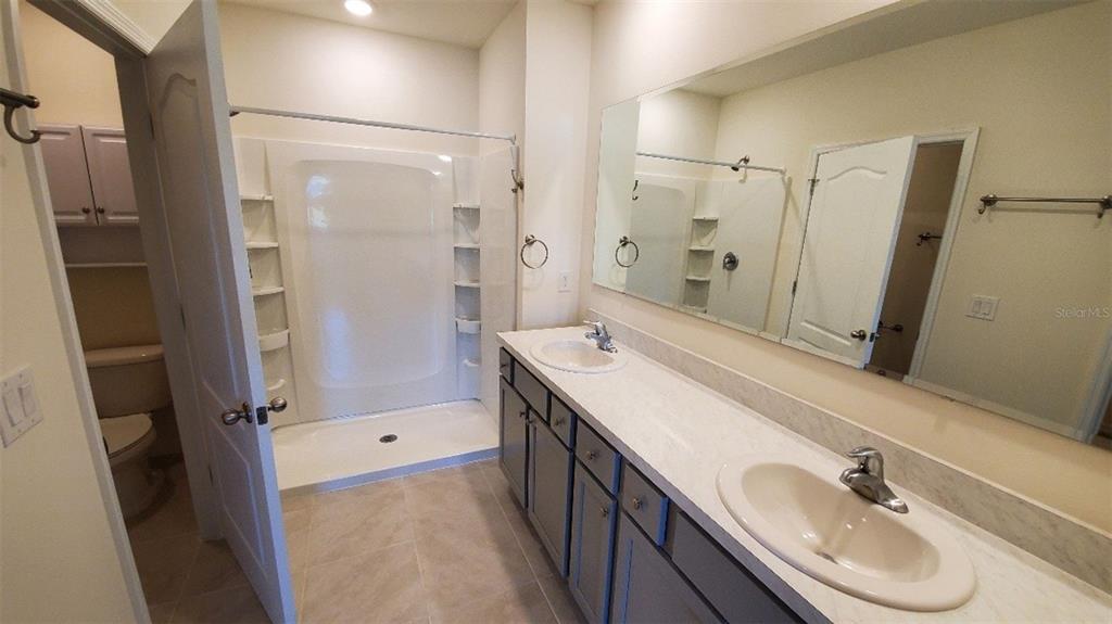 140 Old Mill Edgewater, FL 32141 - Photo 6 of 12 a bathroom with a double vanity sink a mirror and a shower