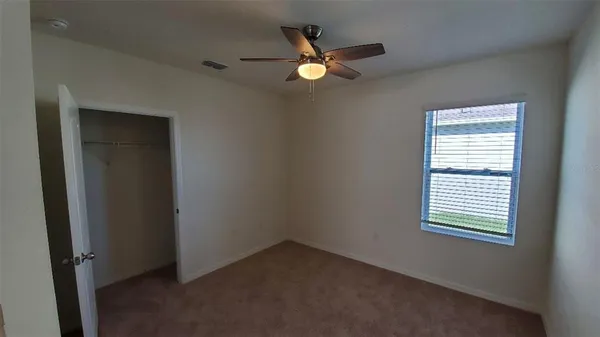 an empty room with closet and windows