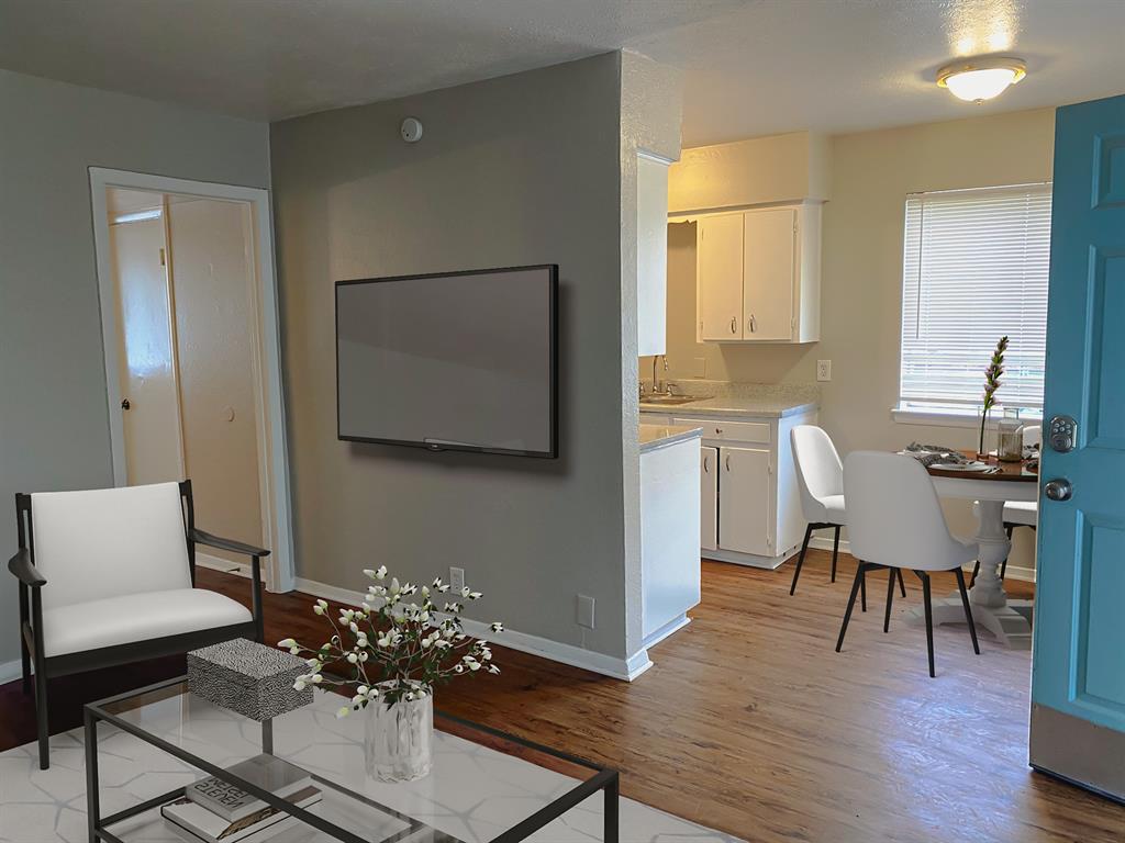 a living room with furniture wooden floor and a flat screen tv