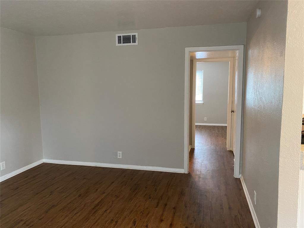 4606 Monarch Street, Unit 104 Dallas, TX 75204 - Photo 7 of 13 Empty room with dark wood-style flooring and baseboards
