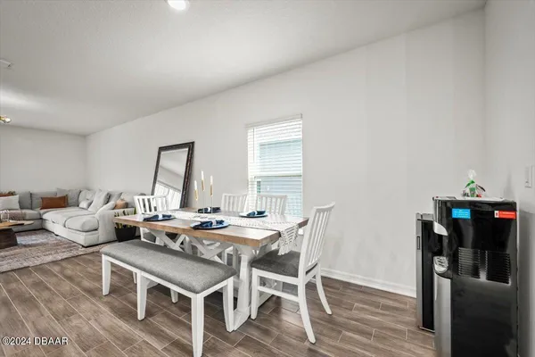 a living room with furniture a wooden floor and next to a window