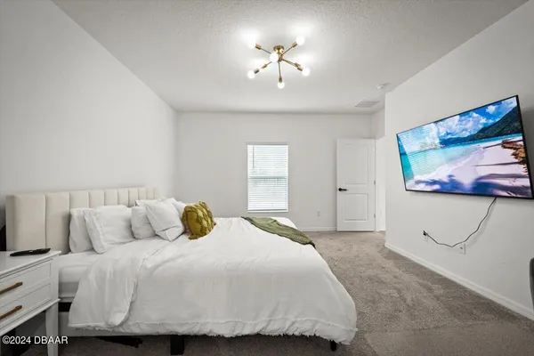 a bedroom with a bed and a painting on the wall