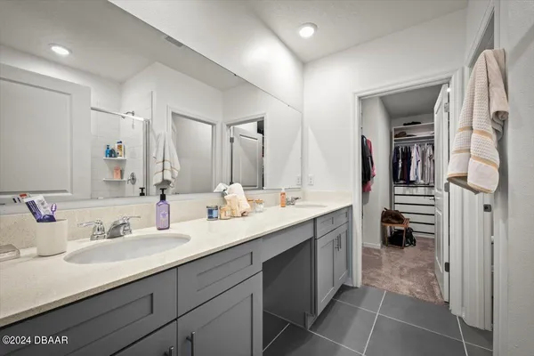 a en suite bathroom with a double vanity sink and a mirror