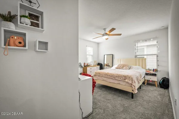 a bedroom with a bed dresser and window
