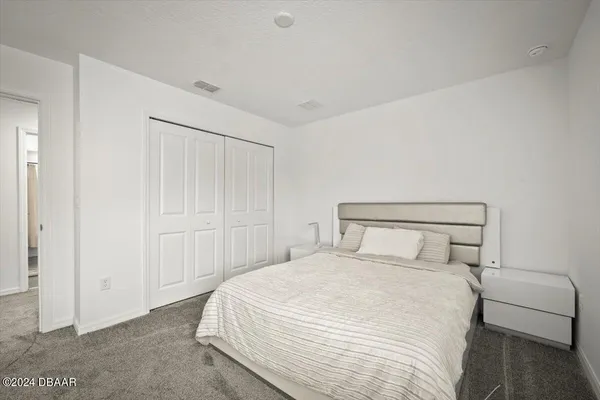 a bedroom with a bed and a night stand