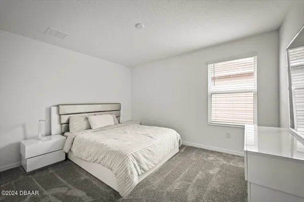 a bedroom with a bed and a large window