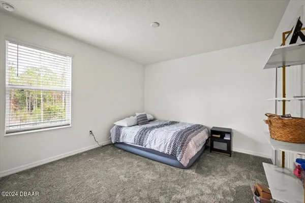 a bed sitting in a room next to a lamp