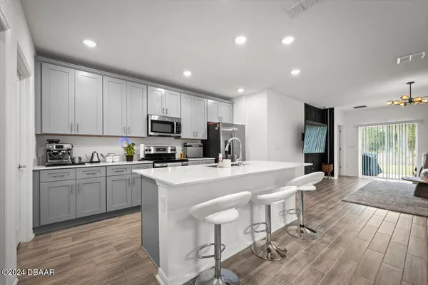 a large kitchen with kitchen island a dining table chairs and refrigerator