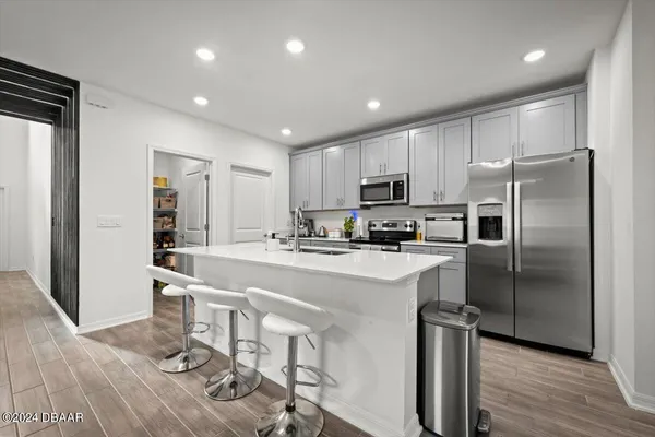 a kitchen with stainless steel appliances a refrigerator sink and microwave