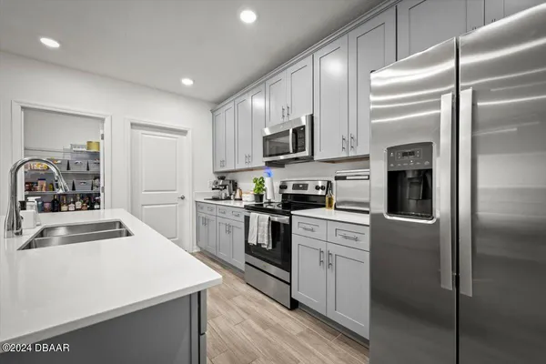 a kitchen with kitchen island white cabinets and stainless steel appliances