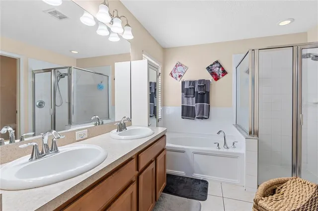 a bathroom with a double vanity sink mirror and bathtub