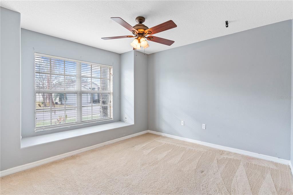 4667 Hickory Stream Lane Mulberry, FL 33860 - Photo 31 of 41 an empty room with window and ceiling fan