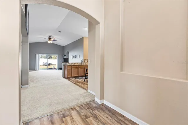 a view of a hallway with wooden floor and furniture