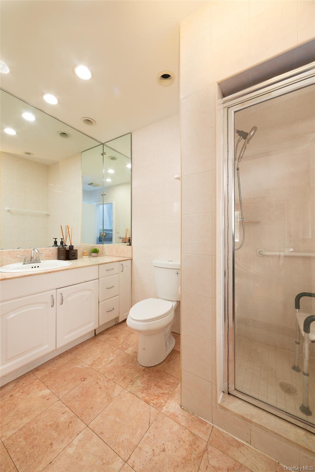 200 Melbourne Road Great Neck, NY 11021 - Photo 13 of 24 a bathroom with a granite countertop sink toilet a mirror and shower