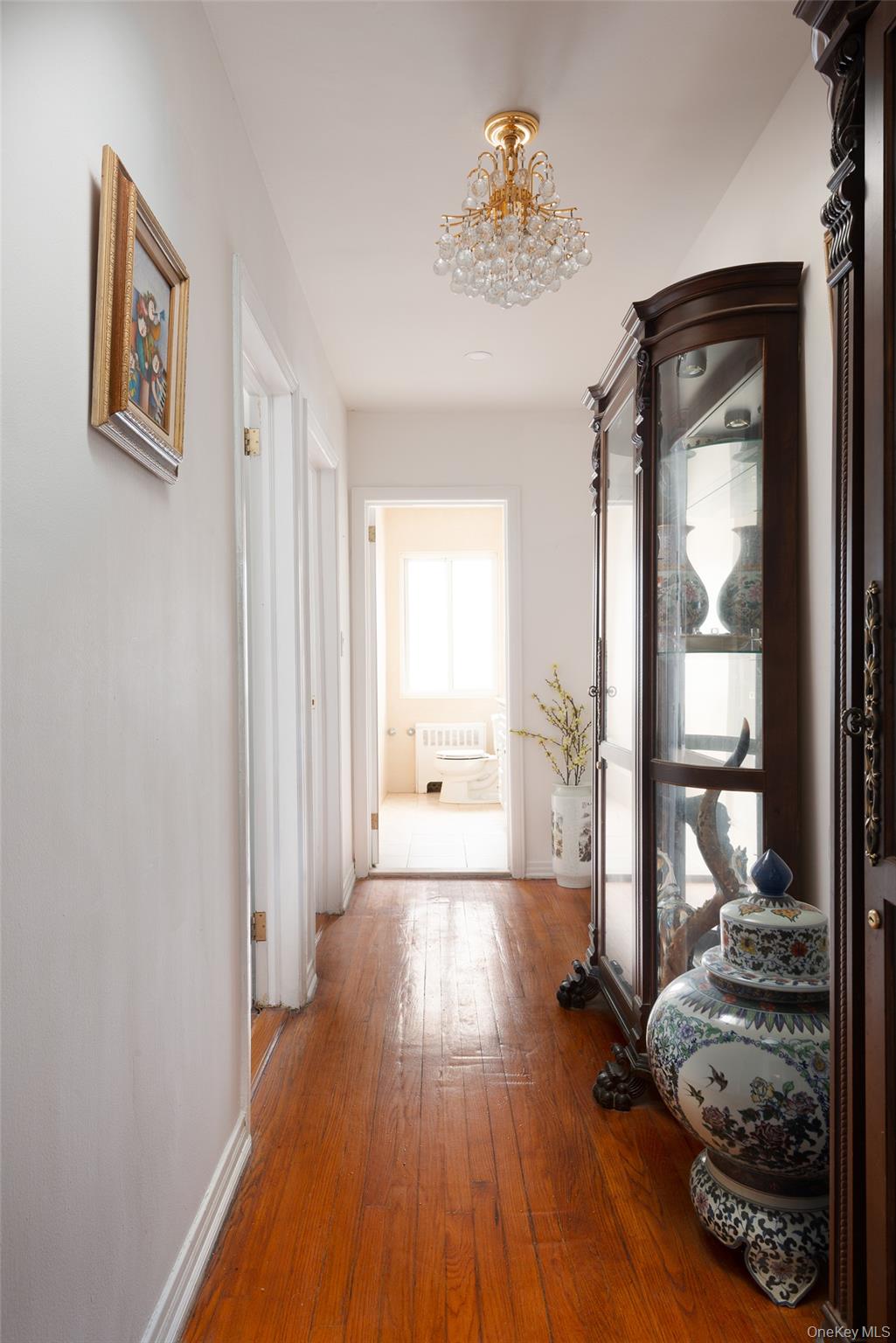 200 Melbourne Road Great Neck, NY 11021 - Photo 15 of 24 a view of a hallway with wooden floor and a livingroom view