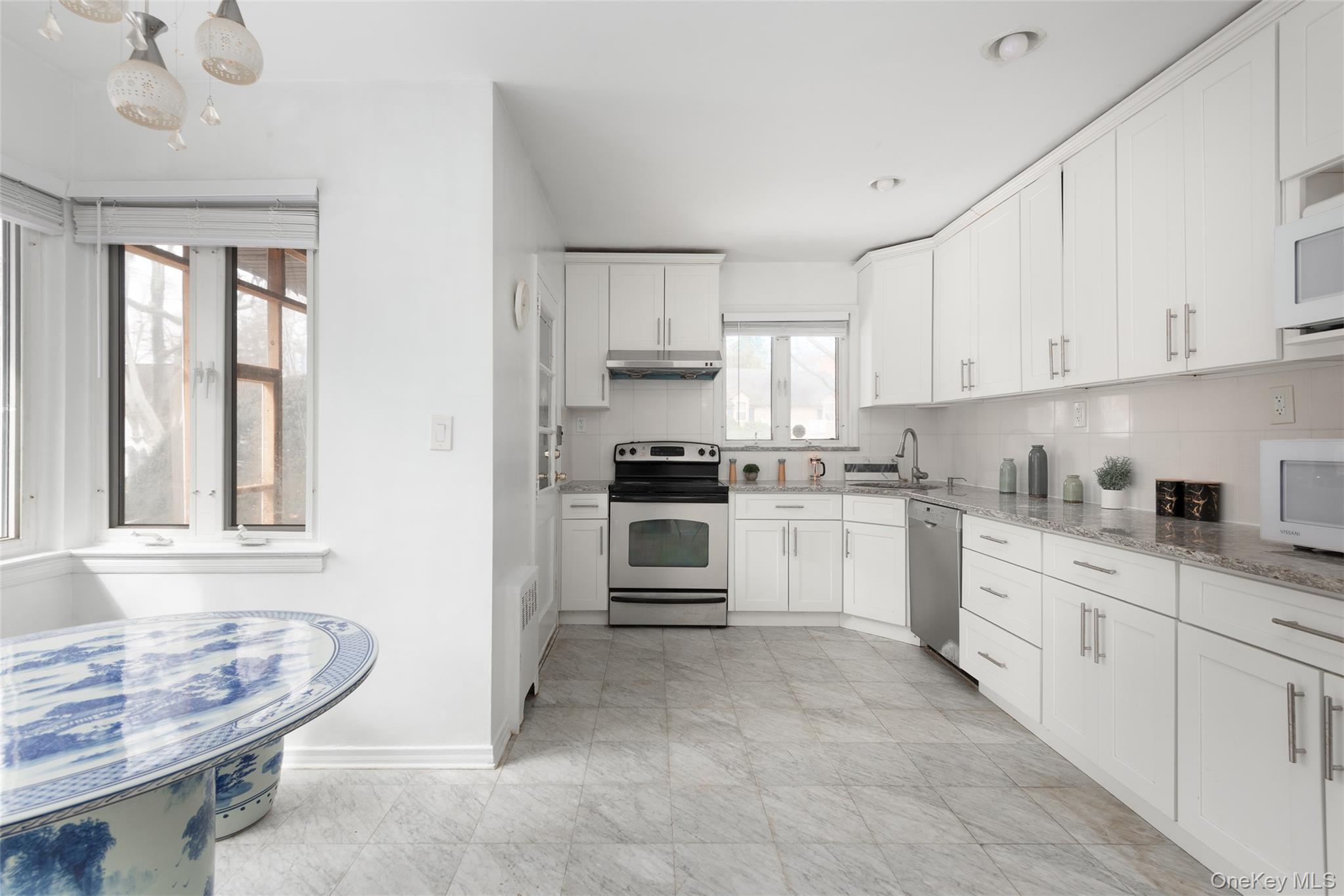 200 Melbourne Road Great Neck, NY 11021 - Photo 3 of 24 a kitchen with granite countertop white cabinets and white appliances