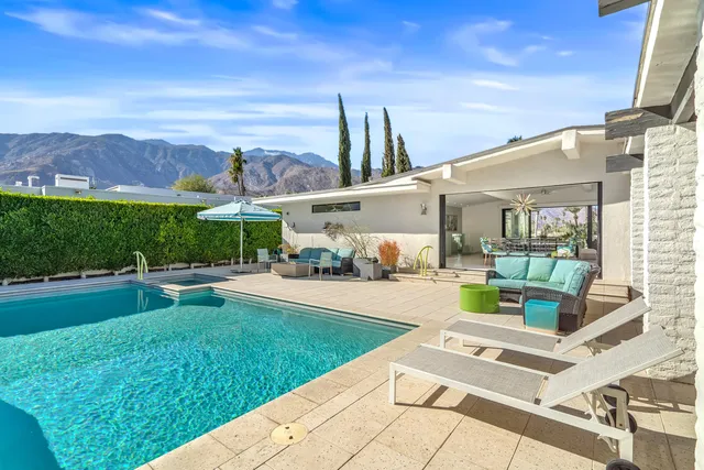 a view of a patio with couches table and chairs and potted plants