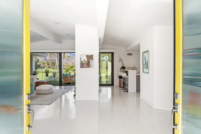 a living room with furniture and a floor to ceiling window