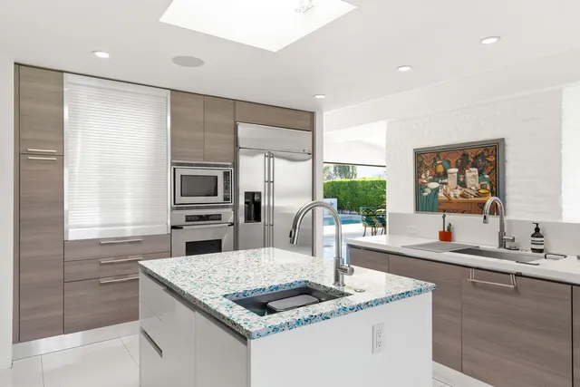 a bathroom with a granite countertop sink a mirror and a shower