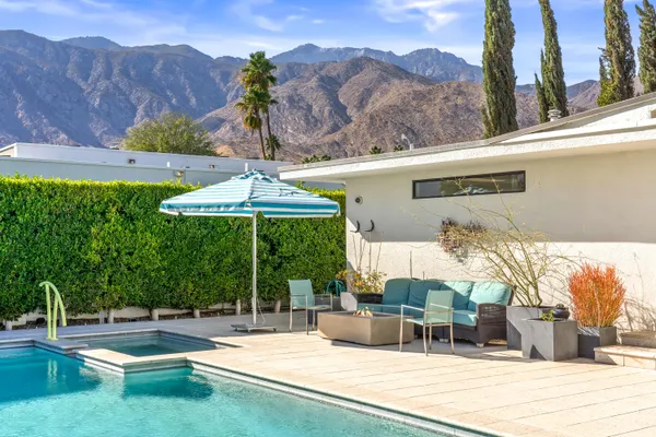 a patio with a table and chairs under an umbrella