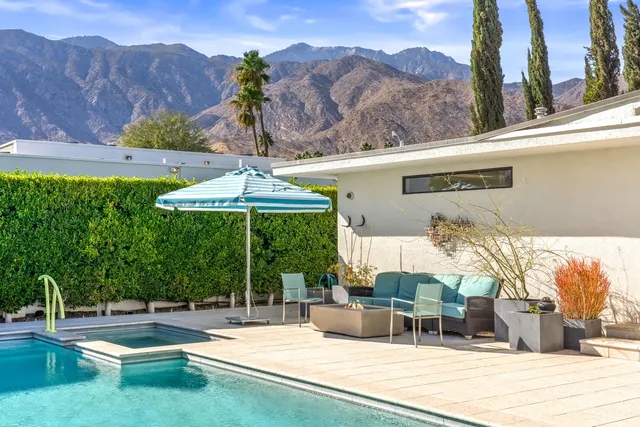 a patio with a table and chairs under an umbrella
