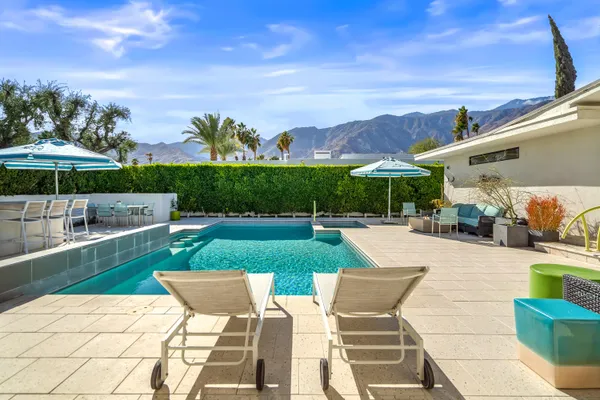 a view of a house with swimming pool and sitting area