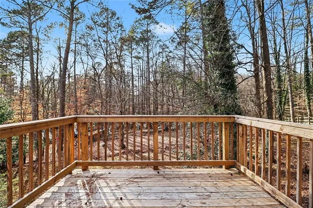 a balcony with wooden floor and trees