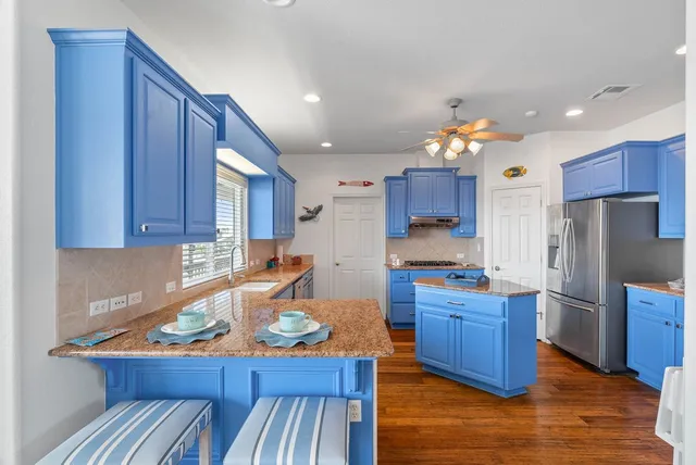 a kitchen with stainless steel appliances granite countertop stove a sink dishwasher and cabinets with wooden floor