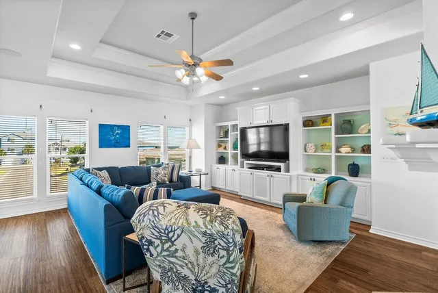 a living room with furniture a ceiling fan and a rug