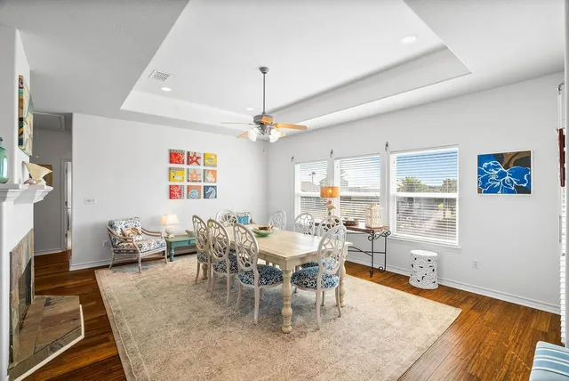 a dining room with furniture a fireplace and wooden floor