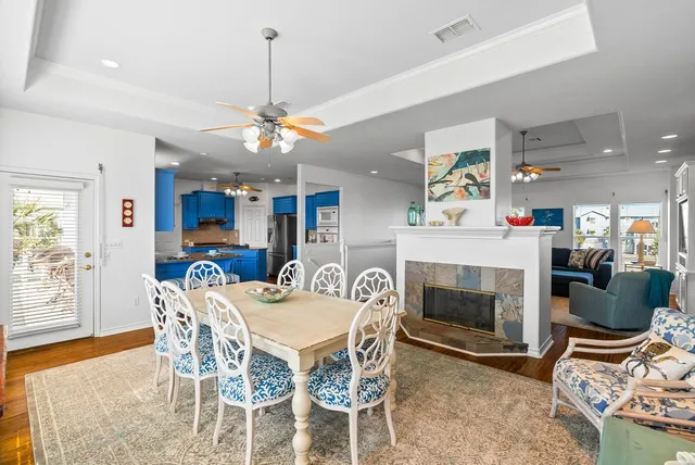 a dining room with wooden floor a chandelier a wooden table and chairs